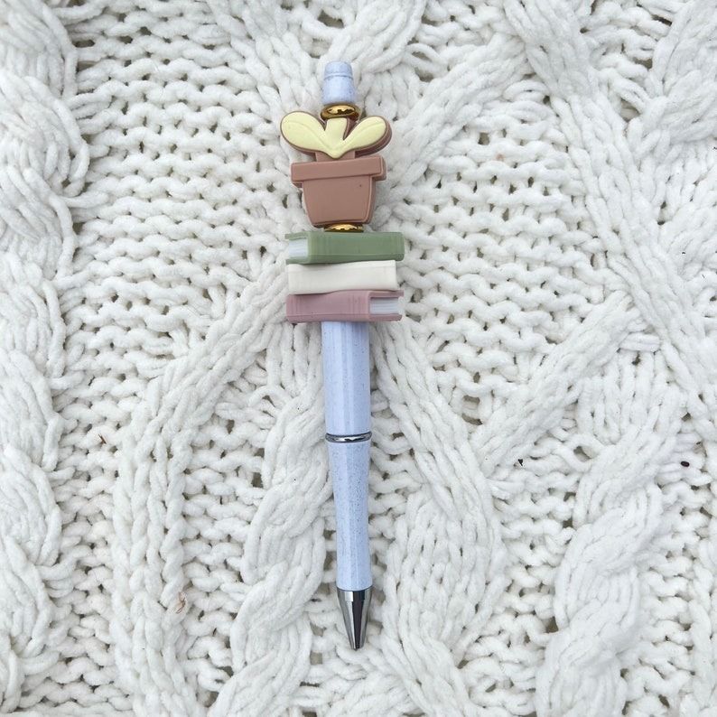 a pen with book charms