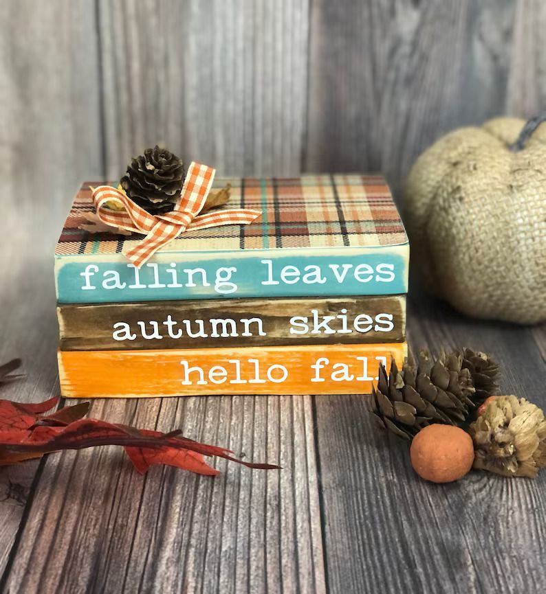 Three books in fall colors that read "falling leaves" "autumn skies" "hello fall"