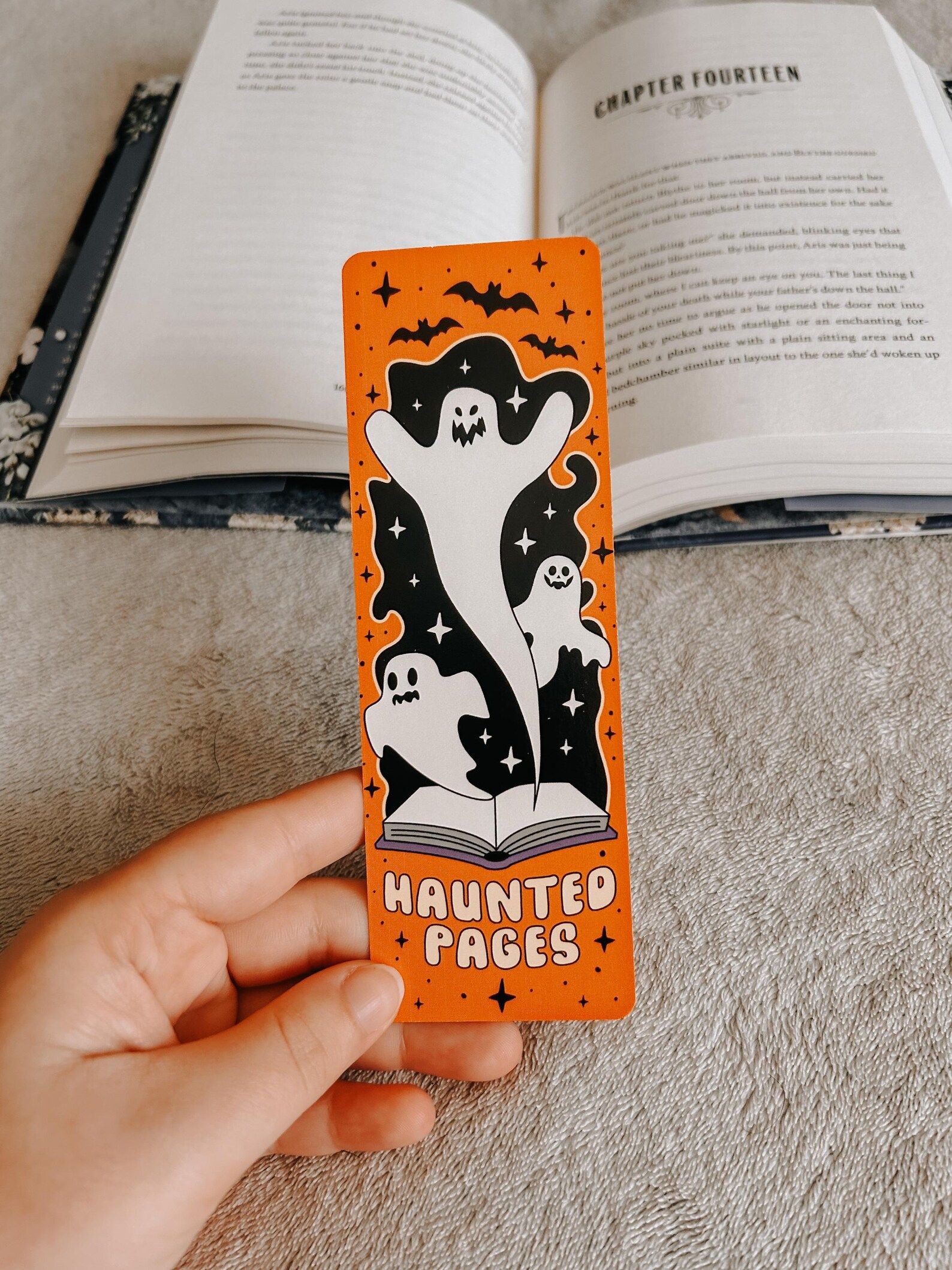 Image of an orange bookmark with ghosts coming out of an open book. It says "haunted pages."