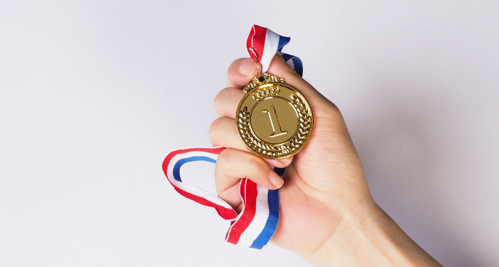 a hand holding a gold medal