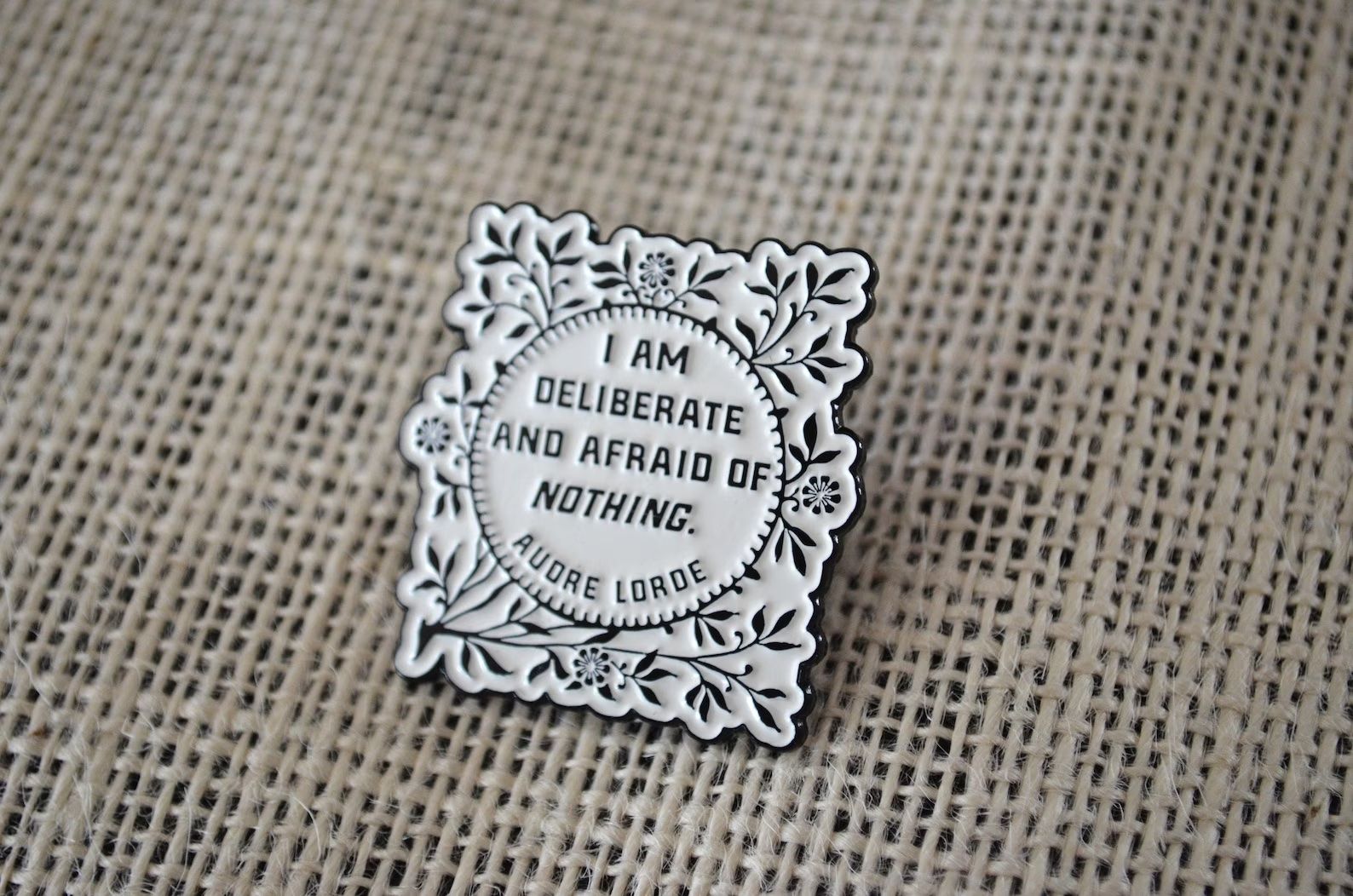 a photo of an enamel pin that says 