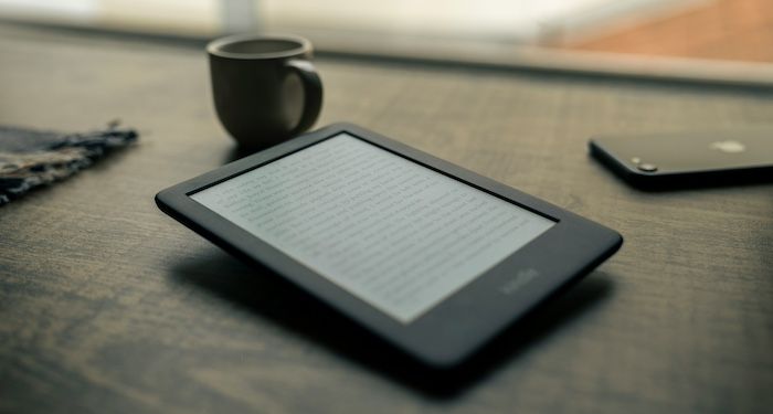 a kindle and a mug on a table