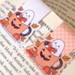 magnetic bookmark of a reading hosts in a jack-o-lantern mug