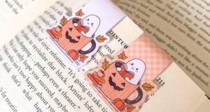 magnetic bookmark of a reading hosts in a jack-o-lantern mug