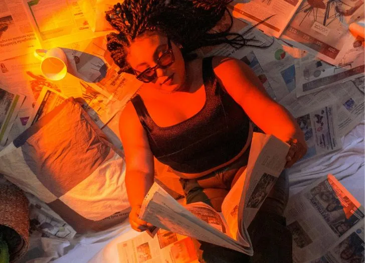 Person reading a newspaper in red light