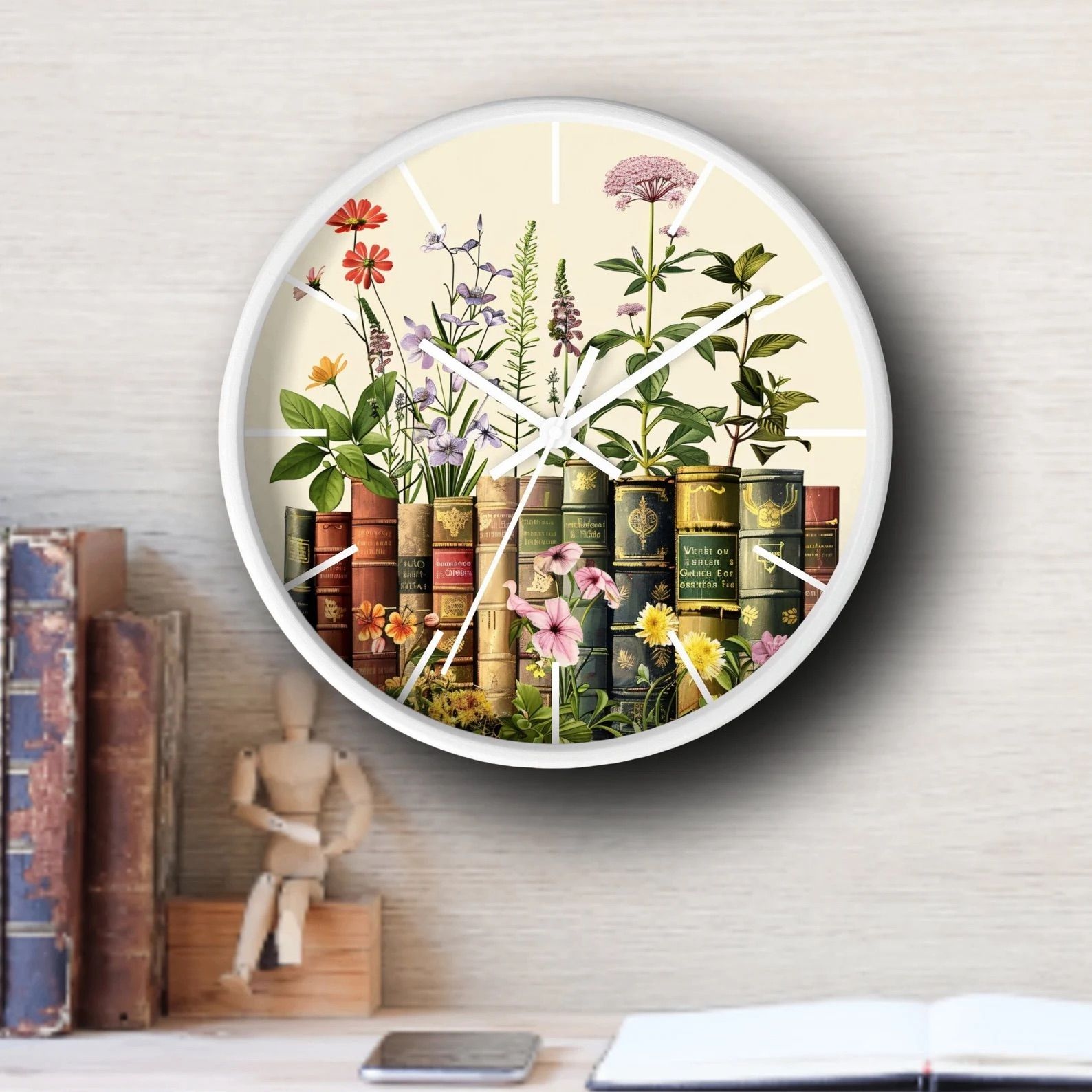 Wildflower and book Wall Clock on white wall next to wood figure and books.