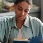 a brown-skinned woman reading a book