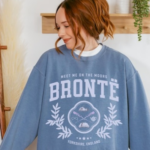 a person wearing a sweatshirt that says Bronte: Meet Me On the Moors