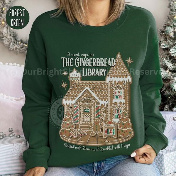 a white woman wearing a green crewneck sweater with that reads "A sweet scape to The Gingerbread Library" hovering over a graphic of a gingerbread house