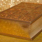 a gold book surrounded by glitter