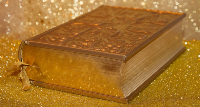 a gold book surrounded by glitter