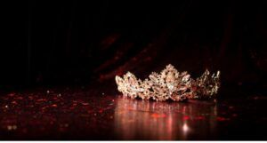 a gold jeweled crown on a surface bathed in red light