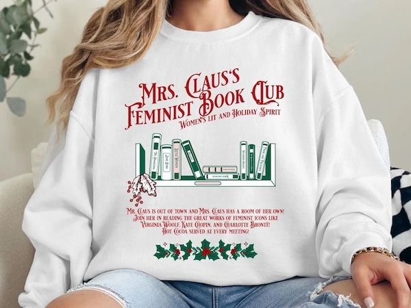 a white woman wearing a white crewneck sweater with text that reads "Mrs. Claus's Feminist Book Club: Women's Lit and Holiday Spirit" hovering over a graphic of book spines on a bookshelf