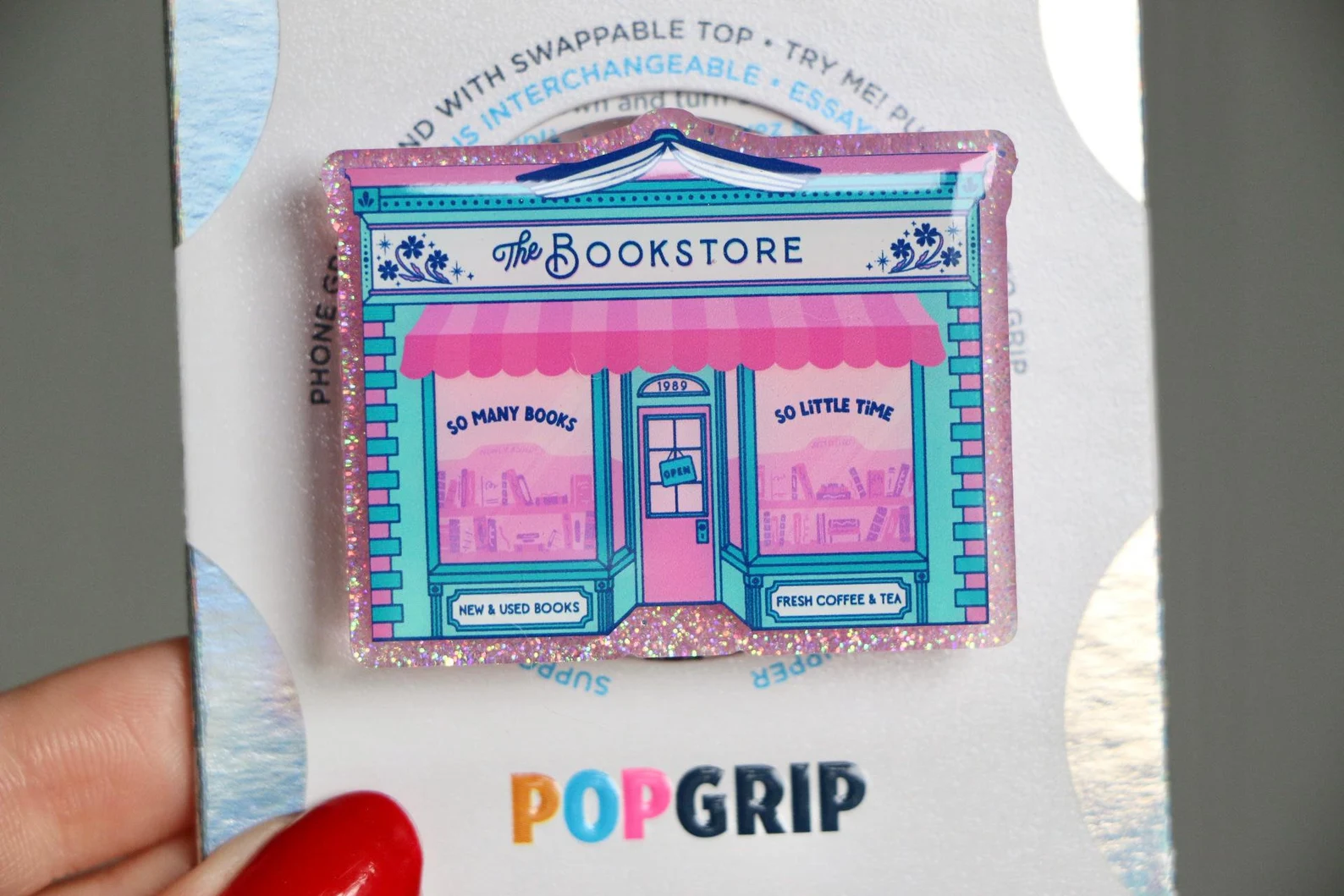 Image of a phone pop grip in the shape of a glittery bookstore. 