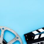 image of a film reel and clapboard on a blue background