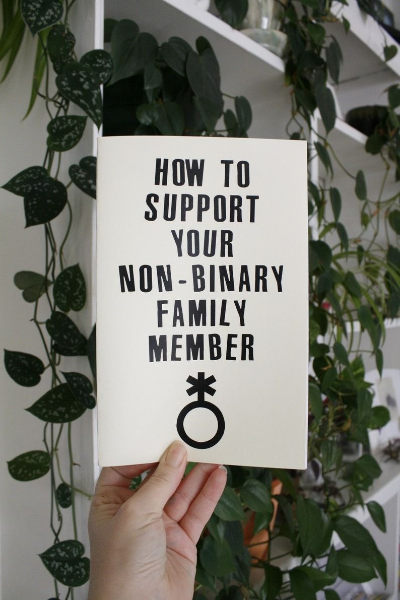 a hand holding up a zine with the title How to Support Your Non-Binary Family Member