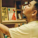 an Asian man looking at books in a bookstore