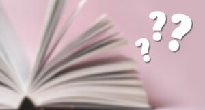 blurry photo of open book with white question marks