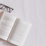 a book with coffee and glasses beside it