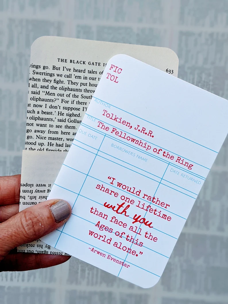 Library card with Tolkien quote in red and envelope made of a book page behind it