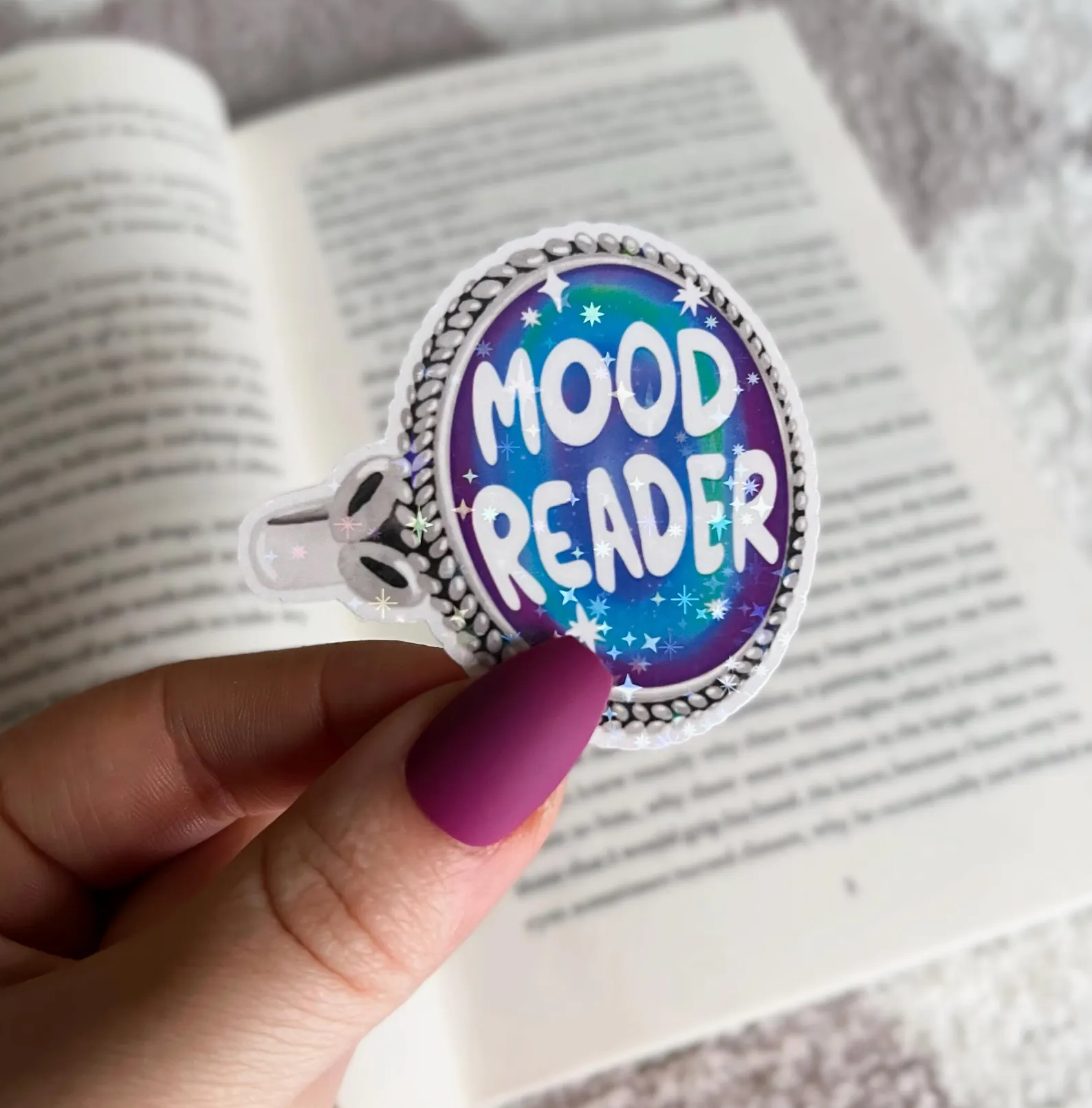 Image of a sticker in the shape of a mood ring. It says "mood reader." 