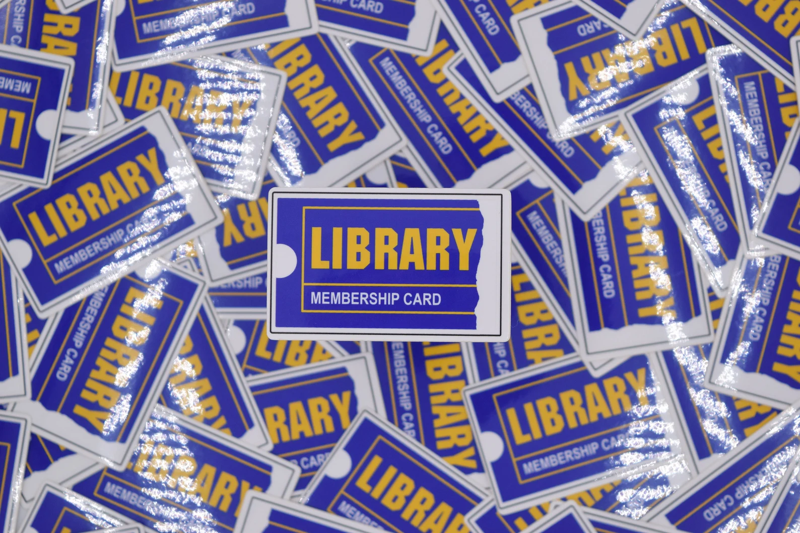 Image of a pile of stickers. They are all fashioned after Blockbuster Video rental cards, but it says "Library Membership Card."