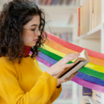 someone browsing a book with a watercolor rainbow behind them