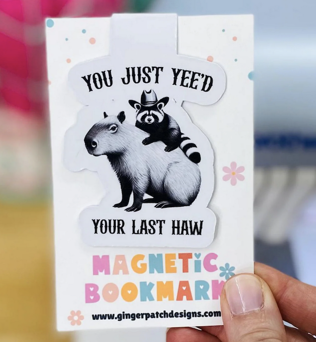 magnetic bookmark illustrated with a raccoon on top of a capybara with text saying you just yeed your last haw