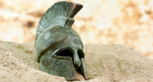 a greek helmet in the sand