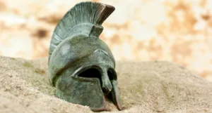 a greek helmet in the sand