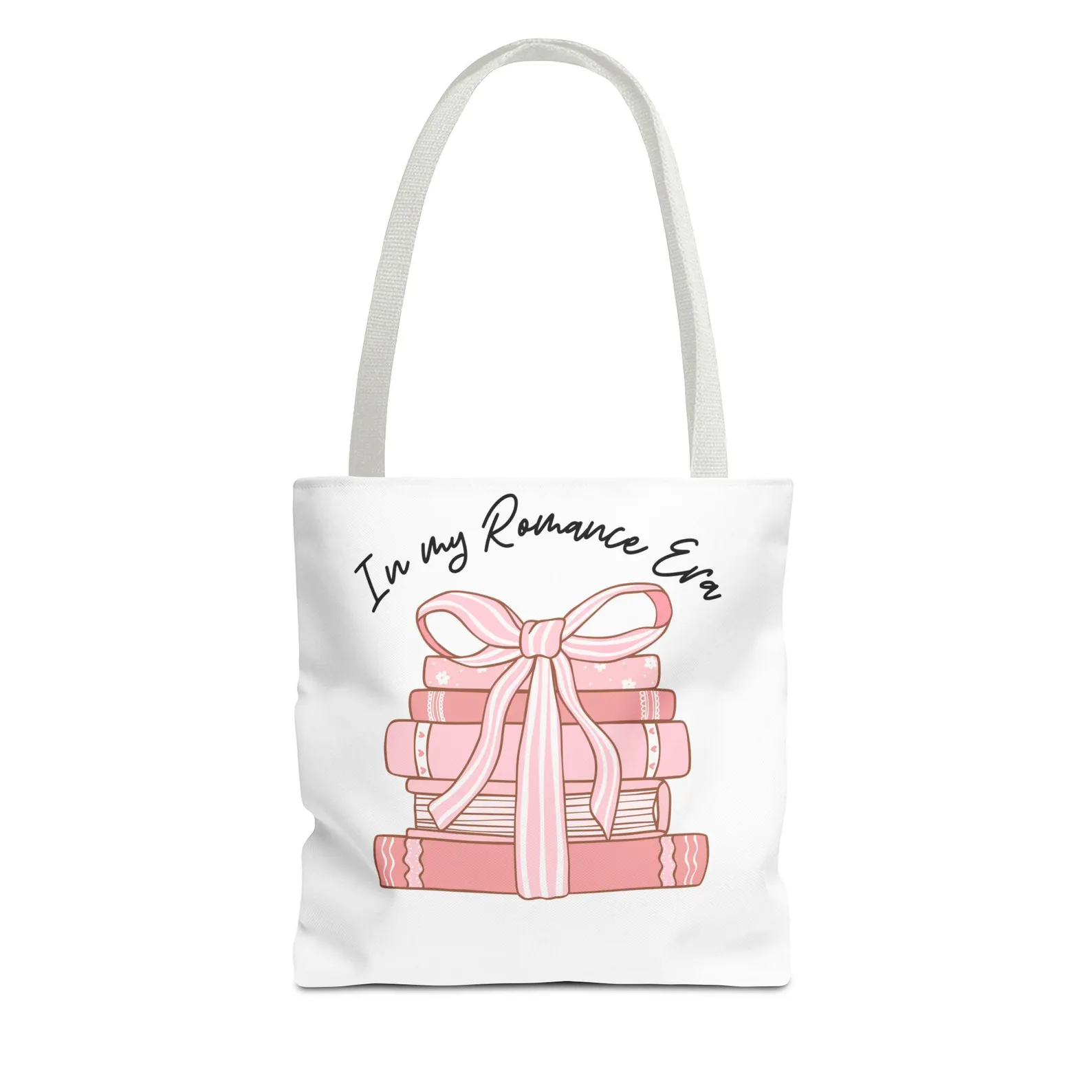 Image of a white tote bag. There is a stack of pink books with a pink ribbon holding them together. In black font above, it reads "in my romance era."