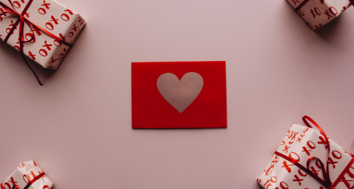 a red card with a heart surrounded by red presents