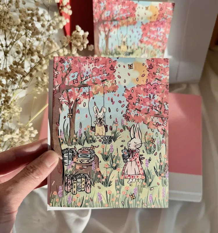 greeting card illustrated with bunnies in a spring garden reading