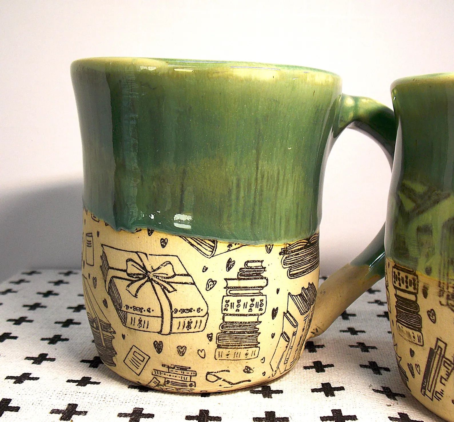 Hand thrown ceramic book mug on a tile countertop.