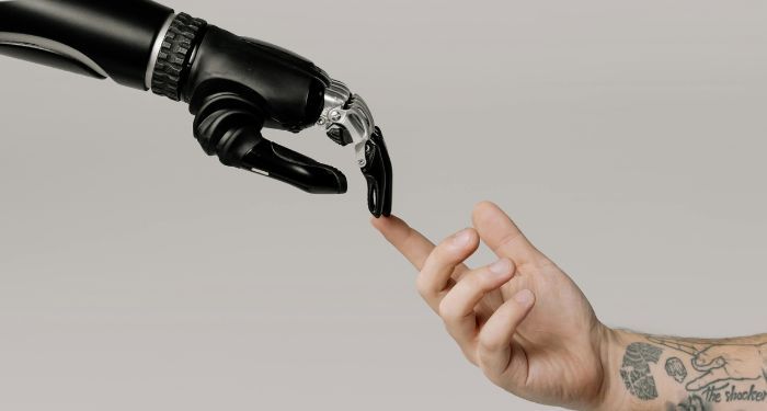 a robot arm touching fingers with a tatted white male arm in the style of the Creation of Adam painting.jpg.optimal