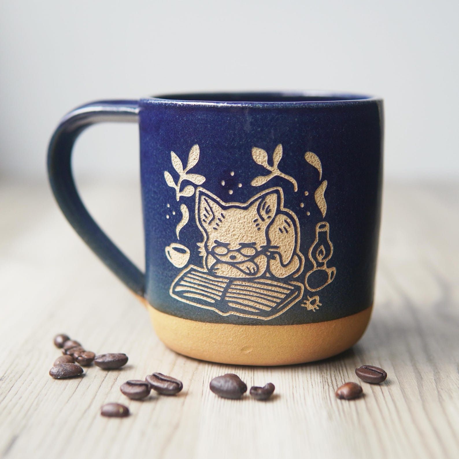 a mug with a design of a cat reading