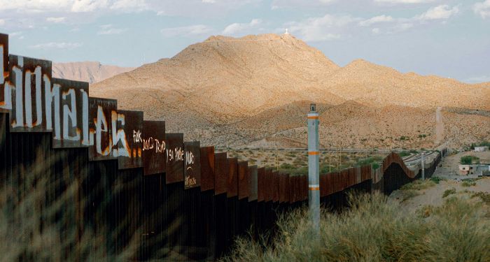 border walls in Mexico against backdrop of mountains and sky