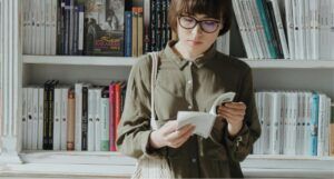 fair-skinned woman with dark bob reading in a bookstore