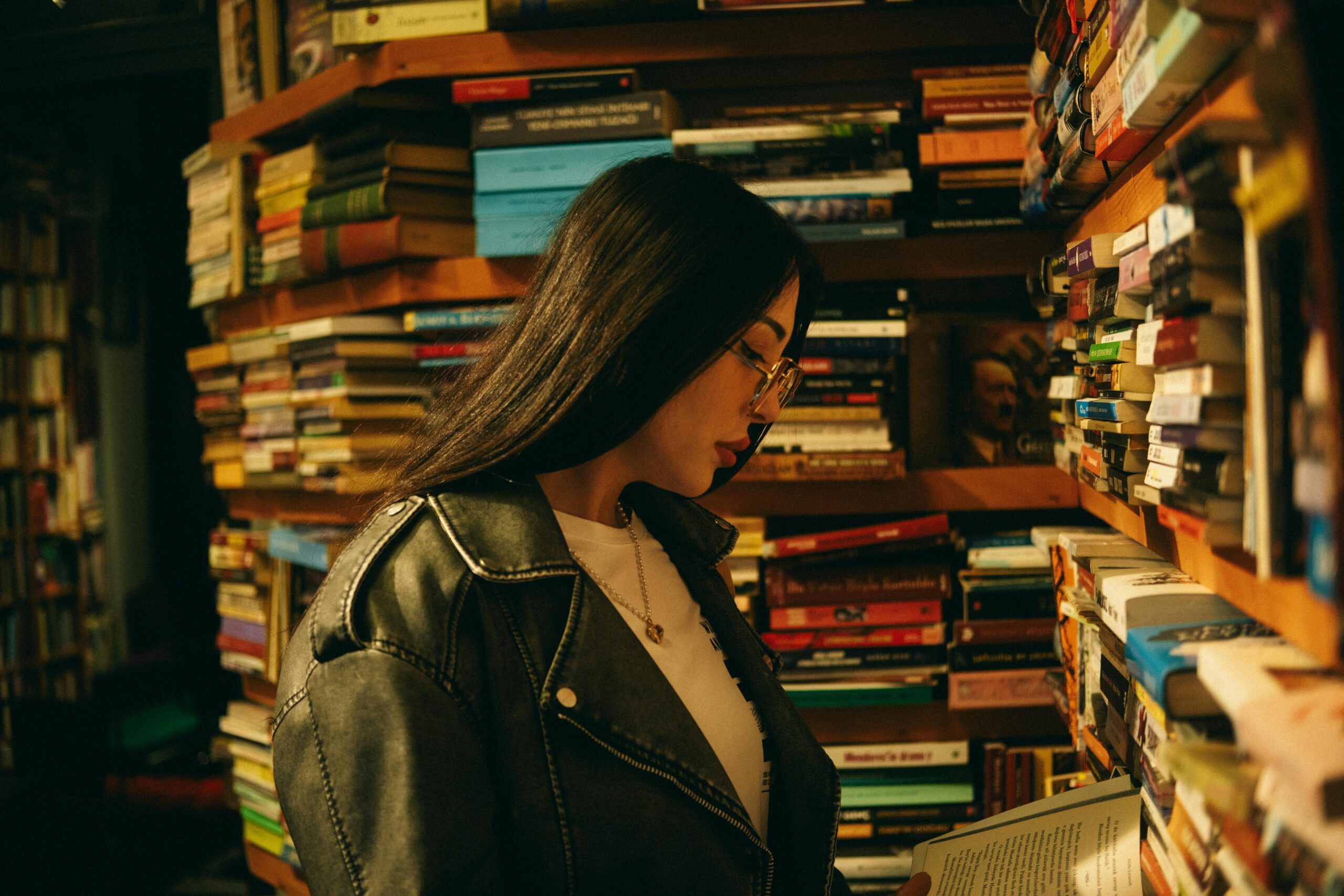 light tan-skinned woman with long dark hair and red lipstick reading a book