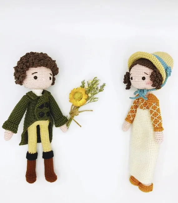 Crocheted figurines of Mr. Darcy holding out flowers to Elizabeth Bennet in a bonnet. 