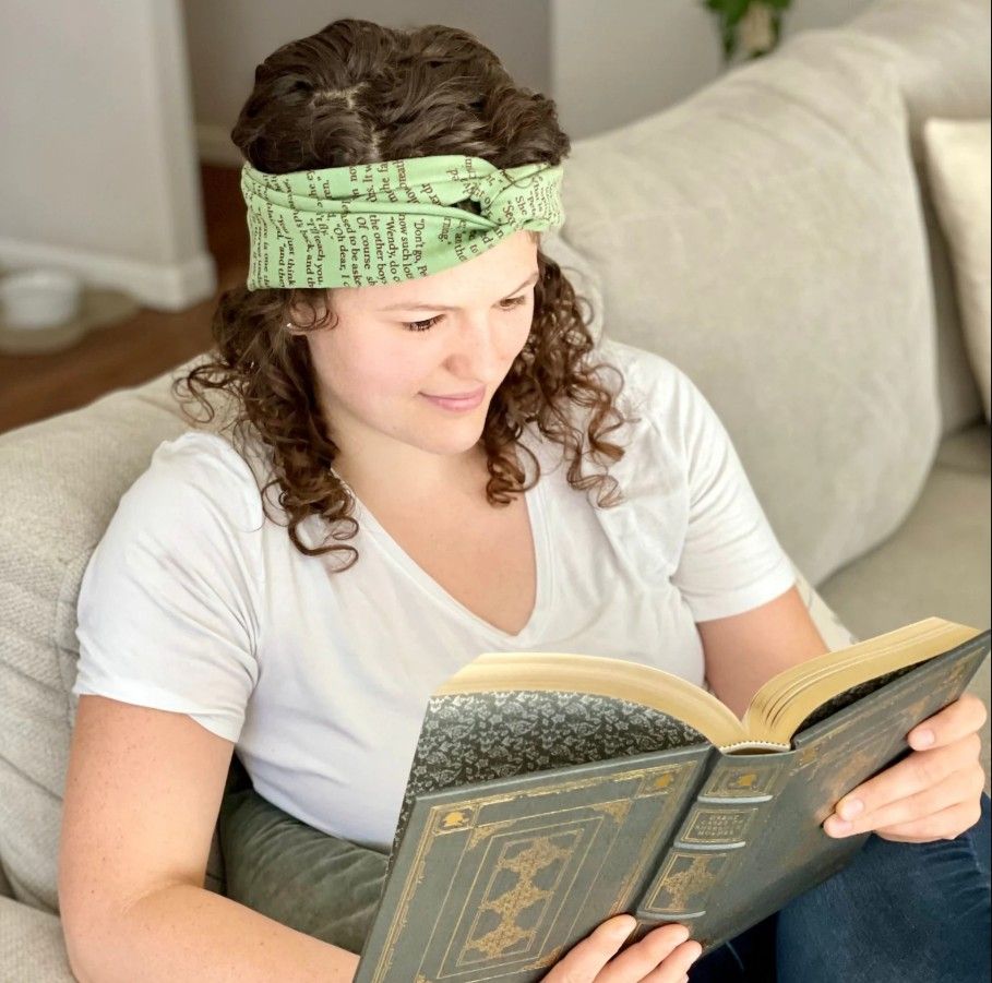 A woman reading with a green scarf on her head