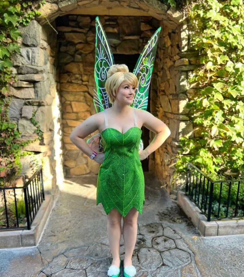 A woman in a green dress with fairy wings on