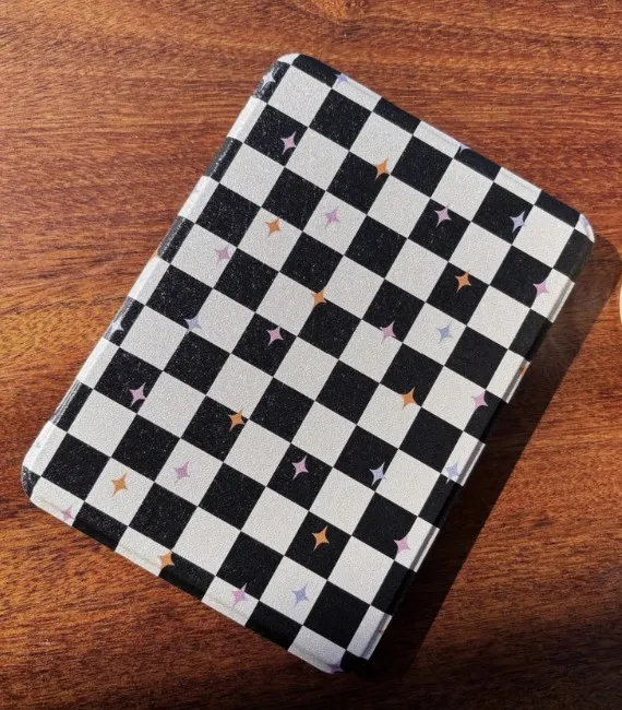 Black and white sparkly checkerboard kindle cover set on a wooden table