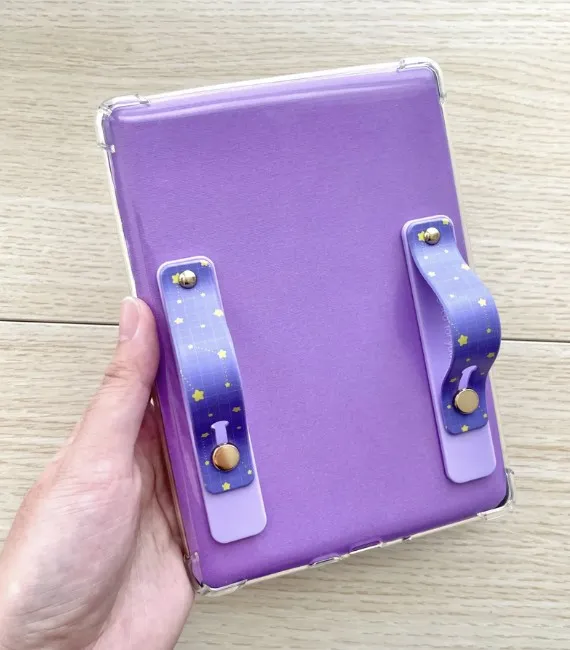 Purple finger grips with a grid and yellow star pattern on a purple kindle case