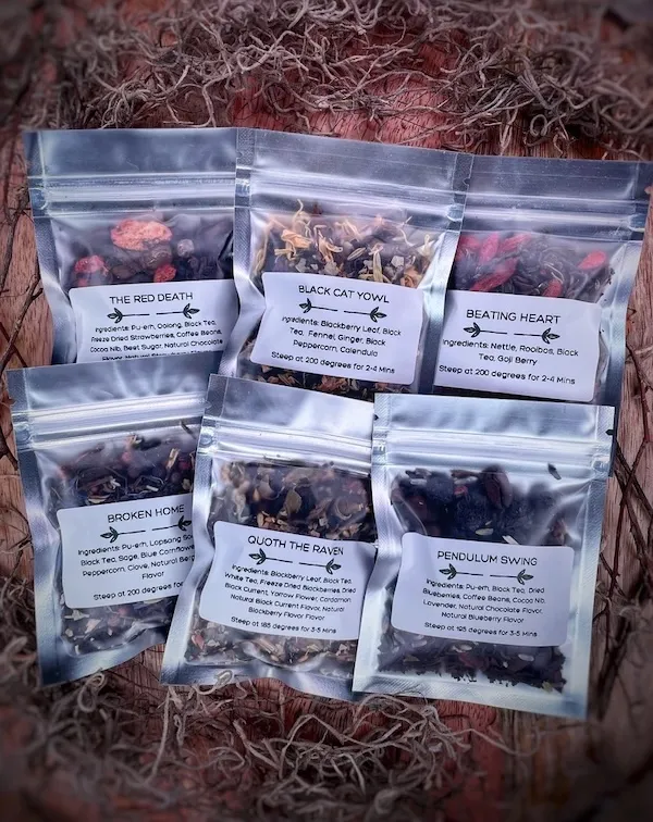 six silver resealable pouches of loose leaf tea with labels for each of the Poe-themed blends: The Red Death, Black Cat Yowl, Beating Heart, Broken Home, Quoth the Raven, and Pendulum Swing