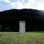 a door in the middle of a field