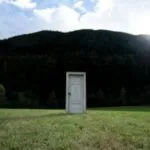 a door in the middle of a field