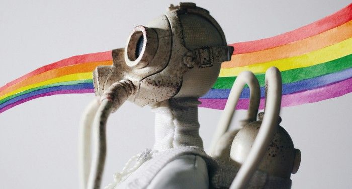 a figurine wearing a gas mask with a rainbow background
