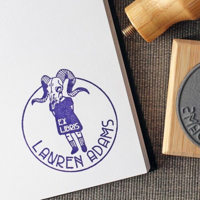 an image of a stamp depicting a person wearing a dress and socks and shoes with a ram skull in place of a head. The dress says Ex Libris and it's personalized with a first and last name