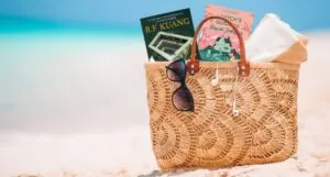 a tote bag on the beach with two fantasy covers sticking out